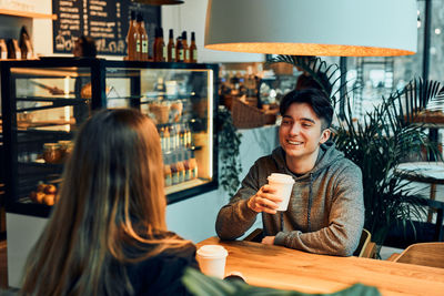 Friends having a chat, talking together, drinking coffee, sitting in a cafe. couple having a break