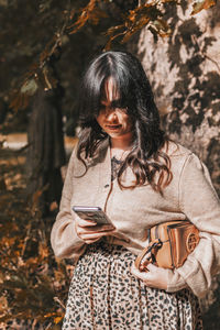 Young woman using mobile phone, autumn, fall.