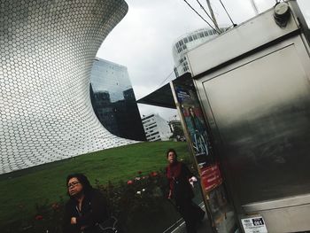 People in modern building against sky