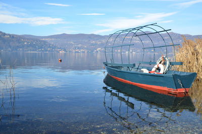 Fishing boat moored in river against sky