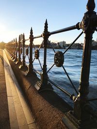 View of wooden posts in sea against sky