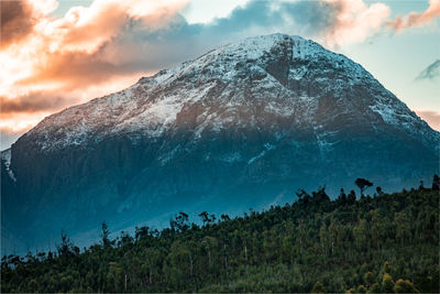 Scenic view of snowcapped mountains against sky during sunset