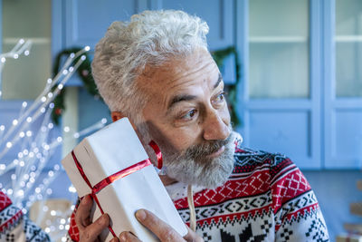 Close-up of man with christmas present at home