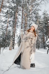 Joyful girl walks in snowdrifts in a snowy forest person