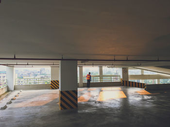 Rear view of worker standing in building parking lot