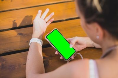 High angle view of woman using smart phone on table