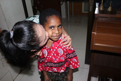 Mother with girl standing at home