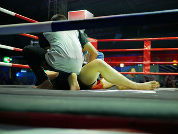 Rear view of men sitting on rope