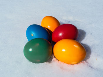 High angle view of multi colored eggs on white background