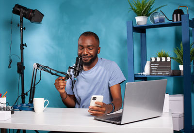 Young man using laptop while sitting on table