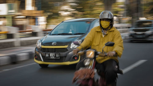 Blurred motion of man riding motorcycle on street