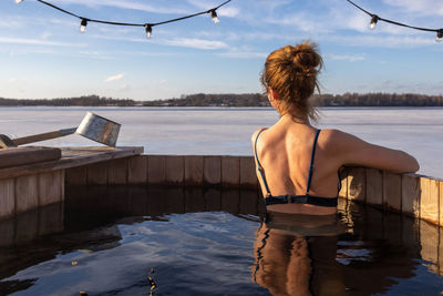 Rear view of woman standing in boat