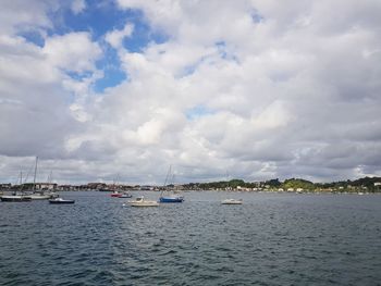 Sailboats moored on sea against sky