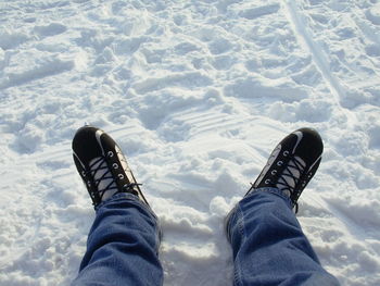 Low section of person standing on snow