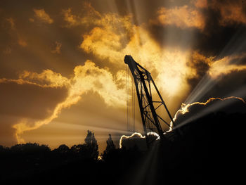 Low angle view of silhouette crane against sky during sunset