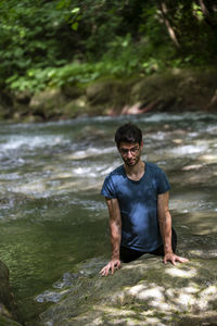 Side view of young man standing in lake