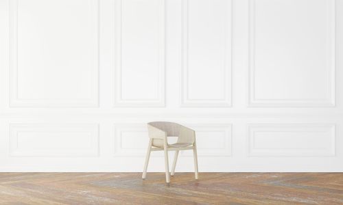 Empty chair against white wall