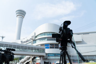 Low angle view of communications tower against sky in city