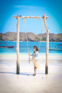 Full length of woman standing on beach sky