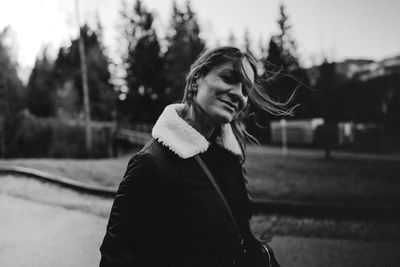 Portrait of young woman with arms crossed standing outdoors