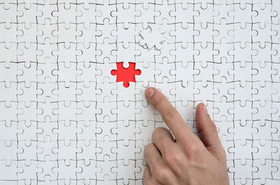 Close-up of human hand playing jigsaw puzzle