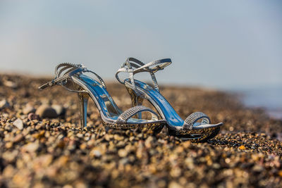 Close-up of shoes on beach