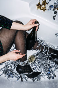 New years party celebration. happy young woman in evening dress sitting in the bathtub drinking
