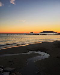 Scenic view of beach against sky during sunset