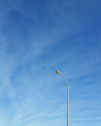 Low angle view of street light against blue sky