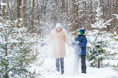 People on snow covered tree during winter