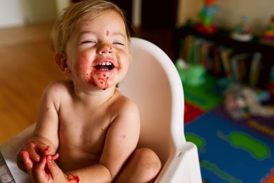 Smiling baby girl sitting in high chair