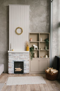 Scandinavian interior of the living room with a fireplace and an open wardrobe with shelves