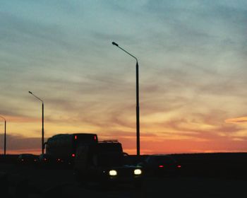 View of vehicles on road at sunset