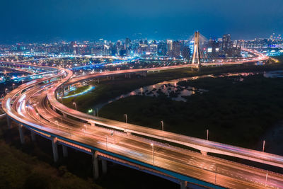 High angle view of light trails on highway in city at night