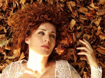 Portrait of young woman with autumn leaves