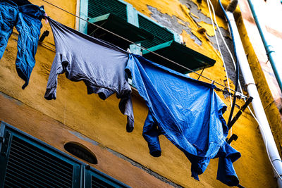 Low angle view of clothes drying against blue sky