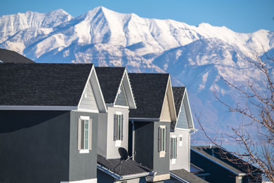 Houses on snowcapped mountains against sky