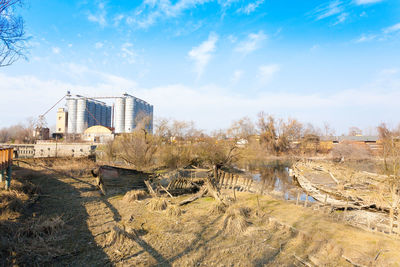 Buildings on field against sky