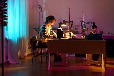 Fashion designer in atelier. young girl seamstress use sewing machine to create bespoke clothes