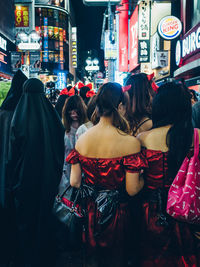 Rear view of people on street at night