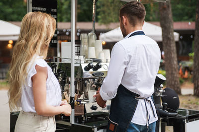 Rear view of barista preparing coffee at stall