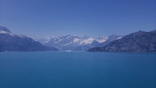 Scenic view of snowcapped mountains against clear blue sky