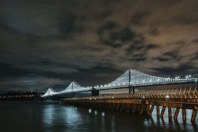 Golden gate bridge over river against cloudy sky