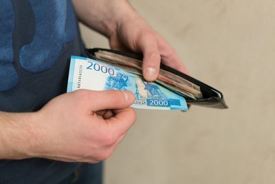 Midsection of man removing paper currency from wallet