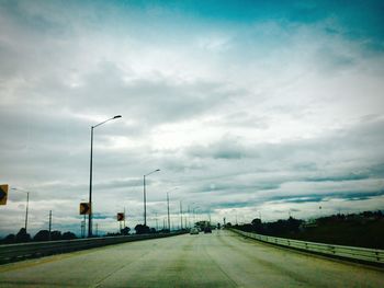 Cars on street against sky