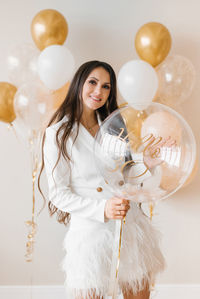 Young caucasian woman holds a balloon in her hands in honor of her thirtieth birthday