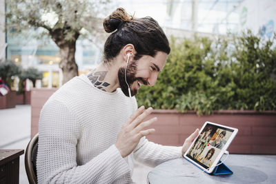 Man using mobile phone while sitting on table