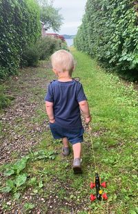 Rear view of boy standing on field