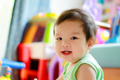 The cute asian boy toddler wearing the green vest are looking for his toy. portrait cute asian baby.