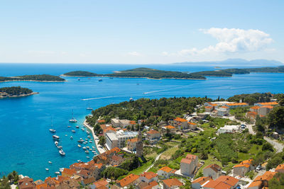 High angle view of town by sea against sky